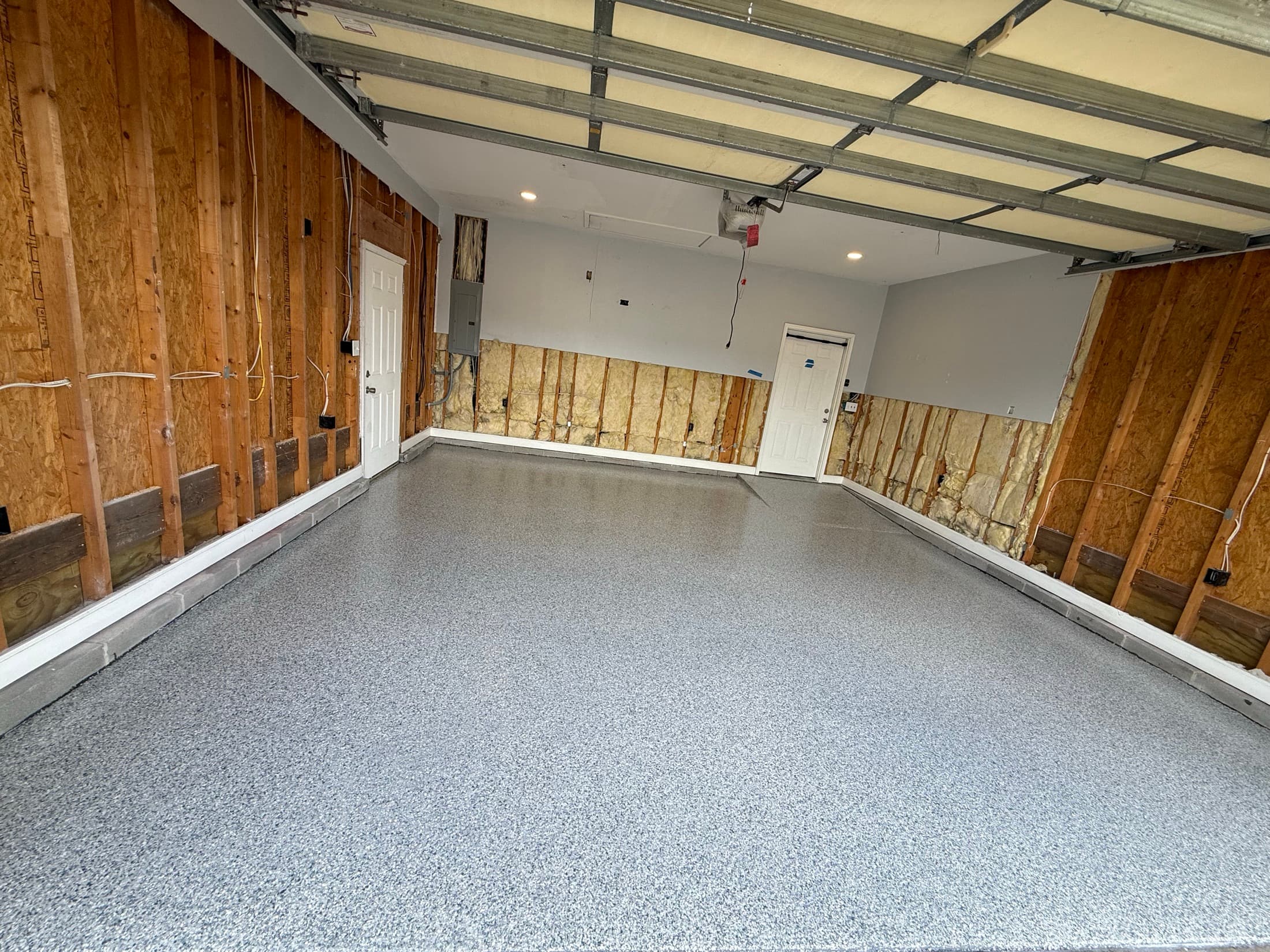 Garage with a new flake epoxy floor, exposed insulation and new recessed lighting